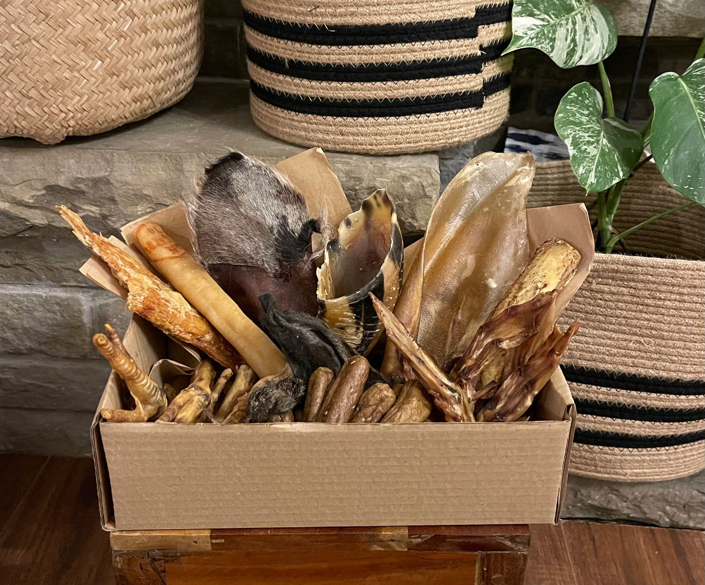 Natural dog treat subscription box with rabbit ears, chicken feet, cow ears, cow hooves, rabbit feet, paddywacks, lamb trotters, tracheas, and other goodies.