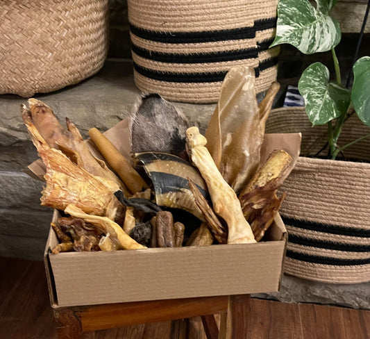 Natural dog treat subscription box with rabbit ears, chicken feet, cow ears, cow hooves, rabbit feet, paddywacks, lamb trotters, tracheas, and other goodies. 