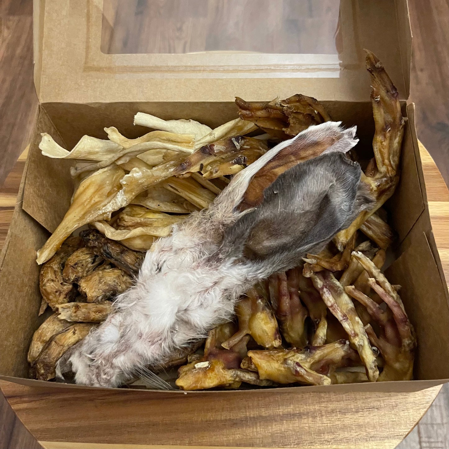 Easter treat box for dogs with chicken feet, chicken necks, chewy lamb skin, rabbit ears and duck feet